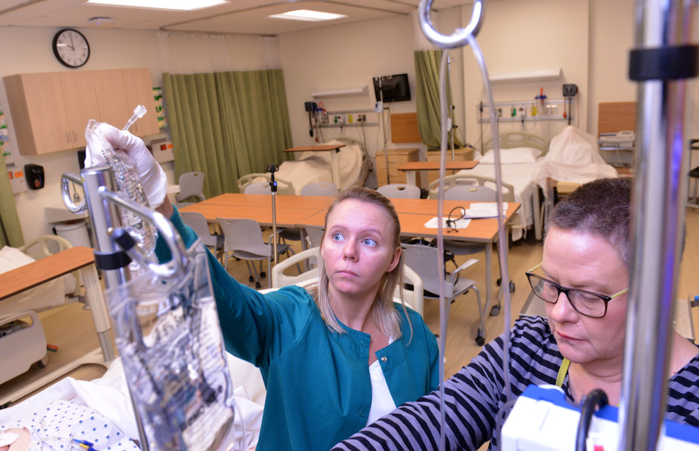 Two health students adjusting an IV